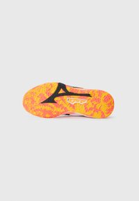 Semelle de chaussure avec une surface texturée, présente un dégradé allant du jaune au rose, avec des accents noirs contrastants. Montre des détails de motif géométrique.