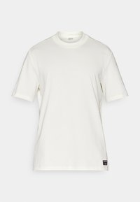 Vit bomullst-shirt med korta ärmar, rundad halsringning, minimalistisk design och en liten logotypmärke nederst till vänster.