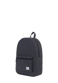 Mochila de tela negra con una parte superior redondeada, bolsillo frontal con cremallera y un parche con el logo. Cuenta con un cierre principal con cremallera y correas de hombro ajustables.