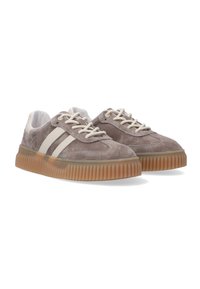 Pair of taupe suede sneakers with white stripes, cream laces, and thick ridged gum sole, shown at three-quarter view on white background.
