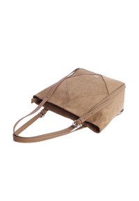Bolso de hombro de gamuza color beige con un diseño geométrico, correa delgada para el hombro y un sutil acento de logo. Textura suave y forma estructurada.