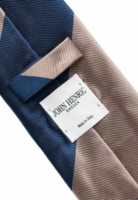 Silkkiside, jossa on vinoraitoja tummansinisessä ja vaaleanruskeassa, valkoisella tarralla, jossa lukee "John Henric Sweden, Made in Italy."