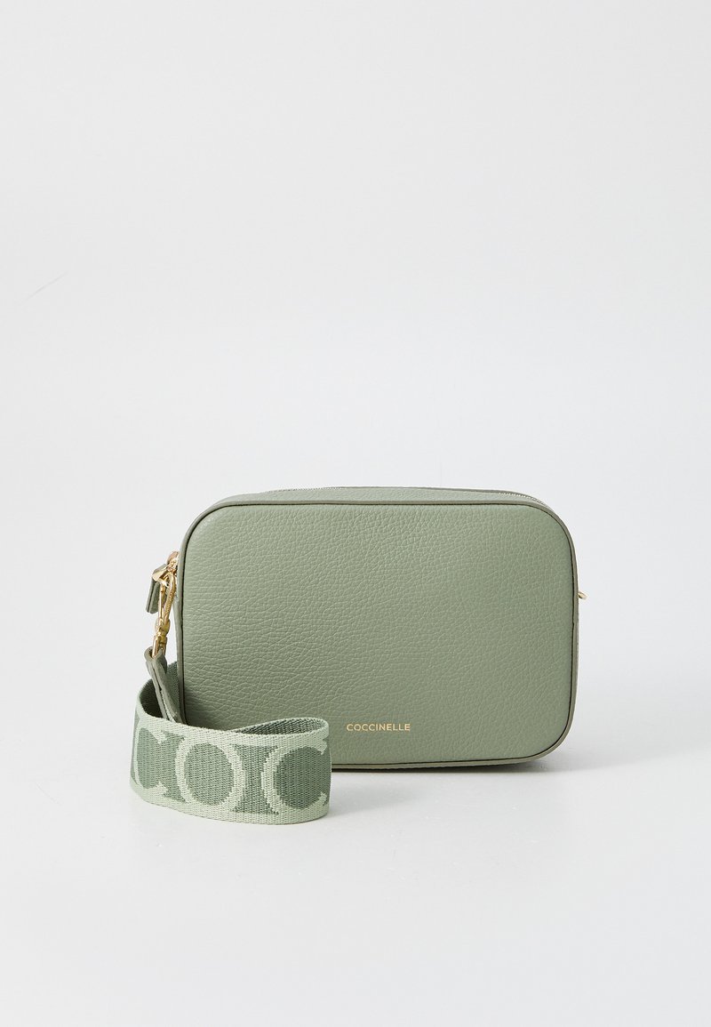 Green leather crossbody bag with a rectangular shape. Features a gold zipper and a fabric strap with a logo pattern. Smooth texture.