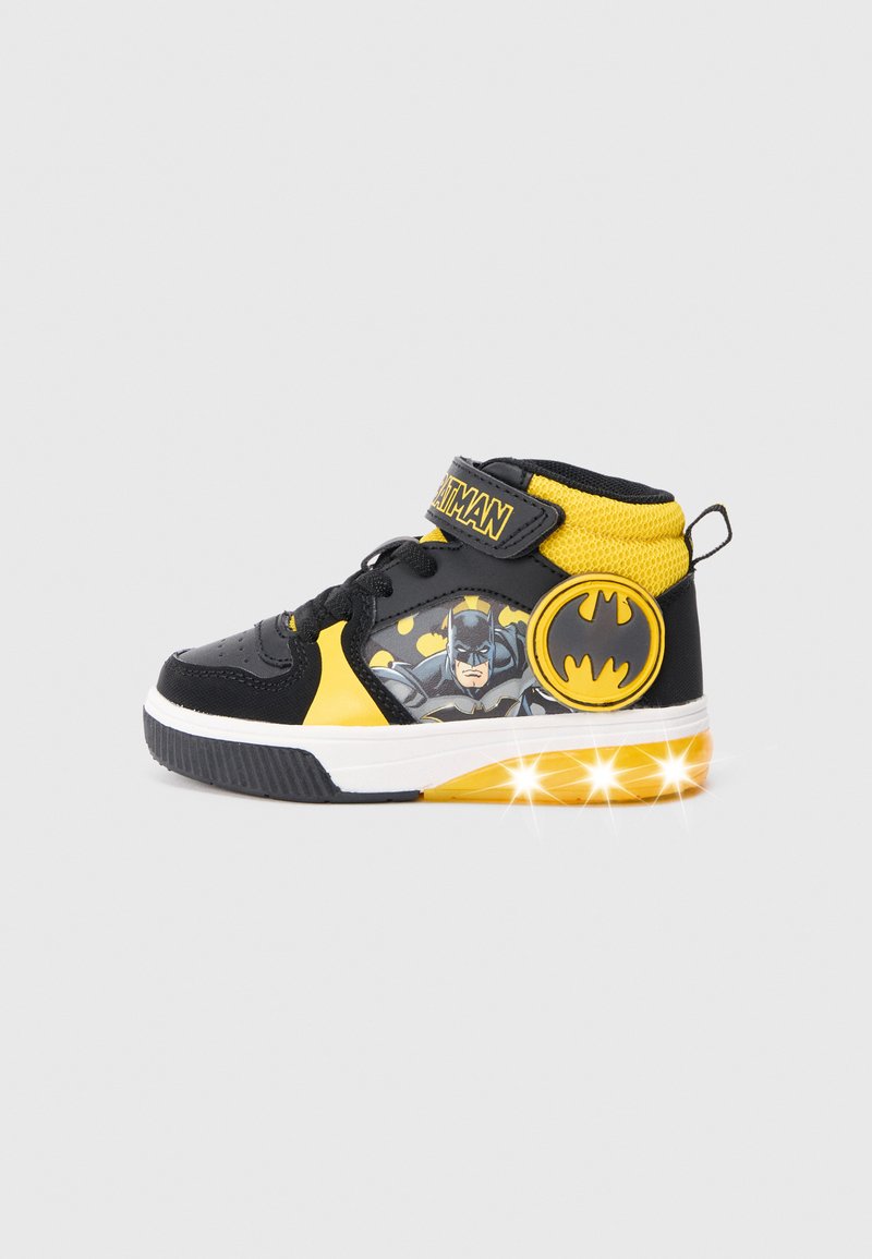 Sorte og gule høj-top sneakers med en Batman-grafik på siden, udstyret med en velcro-rem, mesh-detaljer og lysende såler.