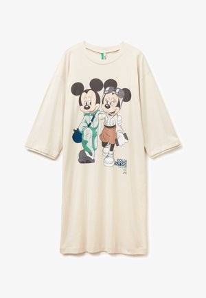 Sukienka z krótkim rękawem w jasnobeżowym kolorze, wykonana z bawełny, z grafiką przedstawiającą dwie postacie z kreskówki oraz nadrukowanym tekstem "KOLORUJ POZA LINIAMI."