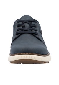 Zapato de cuero azul oscuro con puntera redonda, diseño de cordones y suela de goma blanca. Presenta costuras sutiles y un acento de marca en el lateral.
