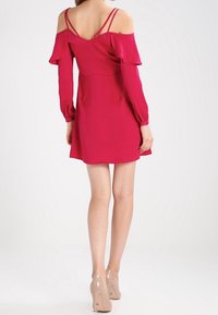 Knallrotes, schulterfreies Kleid mit langen Ärmeln, Rüschendetails und doppelt gewebten Trägern. Glattes, leichtes Material. A-Linien-Silhouette.