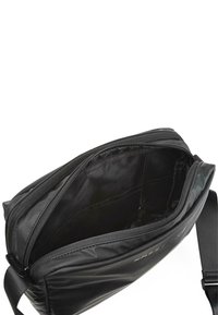 Bolsa de hombro de nailon negro con cierre de cremallera, diseño plano, textura suave y bolsillos interiores para organización.