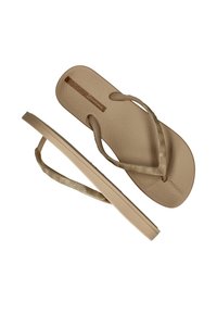 Tanskleurige flip-flop sandalen met een textuurzool en een metallic gouden band met golfpatronen. Flexibel materiaal en een minimalistisch ontwerp.