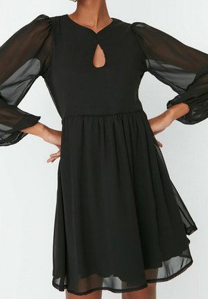 Black dress with sheer, puffed long sleeves, a keyhole neckline, and a flowing skirt, made of lightweight fabric with a smooth texture.