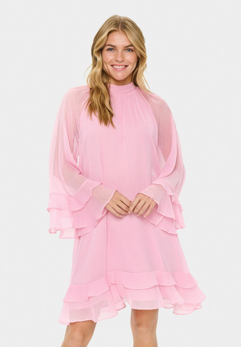 Rosa, fließendes Kleid mit hohem Kragen und rüschierten, langen Ärmeln. Hergestellt aus transparenter Stoff, verfügt es über geschichtete Rüschen am Saum.