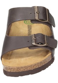 Bruine leren slip-on sandaal met twee verstelbare gespen, kurken voetbed en een getextureerde rubberen zool. Heeft een gevormd voetbedontwerp.
