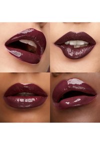 Quattro primi piani di labbra con rossetto lucido color prugna scuro su diverse tonalità di pelle, che mostrano diverse espressioni della bocca e una leggera esposizione dei denti.