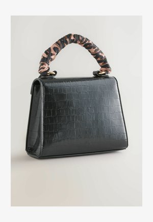 Must musta mustreleed käekott krokodillimustriga, millel on struktureeritud disain, pehme roosa ja musta kangast käepide, millel on kuldsed aksessuaarid.