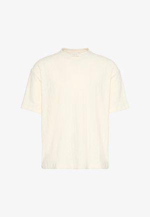 Kremowy top z krótkim rękawem, wykonany na drutach, z delikatnym pionowym wzorem warkocza i okrągłym dekoltem, prezentowany na białym tle.