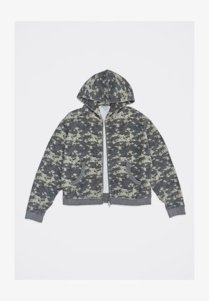 Jakna z zadrgo in kapuco s sivim in svetlo bež digitalnim kamuflažnim vzorcem, dvema prednjima žepoma ter rebrastimi manšetami in spodnjim robom.