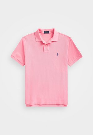 Pink polo shirt med korte ærmer, krave, to knapper og et lille blåt broderet logo på venstre brystområde.