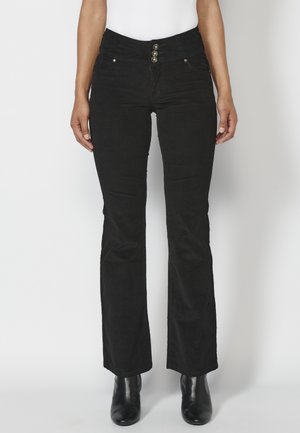 Black flared jeans with a high waistband, featuring three metallic buttons and front pockets. Made from denim with a soft texture.