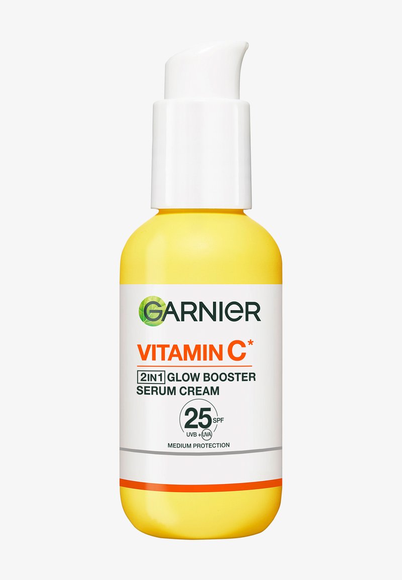 Gul flaske med Garnier Vitamin C 2-i-1 glow booster serumcreme med SPF 25 middel UVB- og UVA-beskyttelse og hvid pumpe.