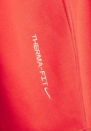 Tejido atlético rojo con "THERMA-FIT" bordado en blanco. Textura suave con detalle de costura visible.