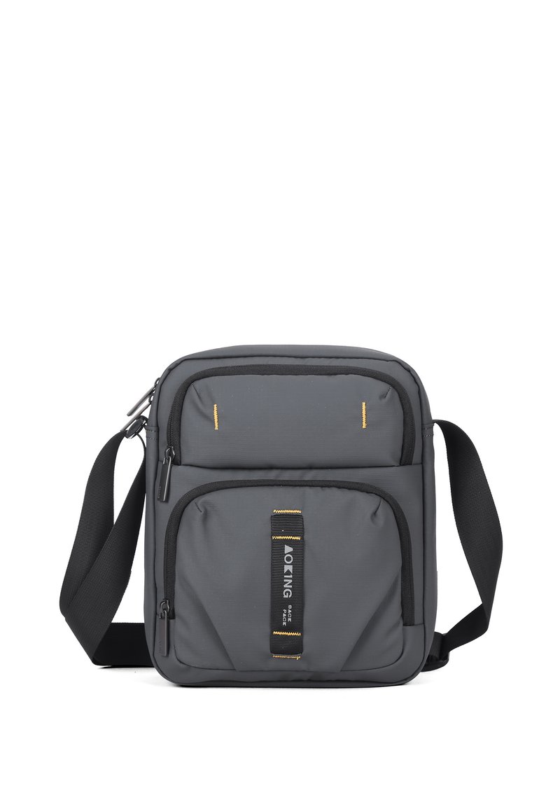 Borsa a tracolla grigia con superficie testurizzata, doppie tasche anteriori e cuciture gialle. Presenta una tracolla regolabile e una patch con il logo.