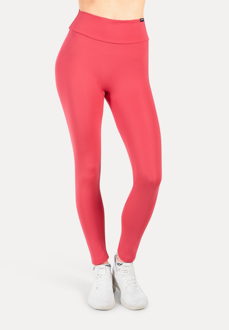 Leggings a vita alta, aderenti, realizzati in tessuto elastico e liscio di un vivace colore corallo, dotati di un design senza cuciture e lunghezza alla caviglia.