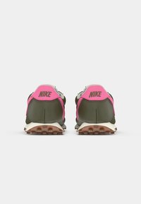 Zaļi un rozā Nike apavi ir ar sietveida augšdaļu, mīkstinātu apkakli un gumijas zoli ar izteiktu saķeres rakstu. Logo uz papēža.