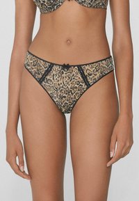 String léopard avec une bordure en dentelle, des accents noirs et un petit nœud à l'avant. Fabriqué en tissu léger.