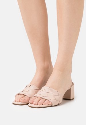 Bleekroze wedge-sandalen met een geweven leren bovenwerk, open teen en blokhak. Gladde textuur met een stevige basis, geschikt voor casual kleding.