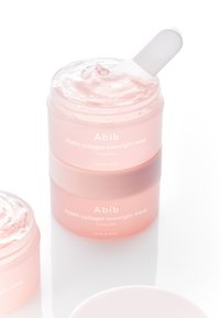 Maschera notte Abib PDRN al collagene in un design impilato. Contiene un gel rosa traslucido in un barattolo rotondo trasparente e satinato con un cucchiaio bianco.