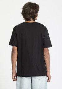 Sort bomulds T-shirt med korte ærmer, rund hals, afslappet pasform og lige kant. Baggrund er helt hvid.