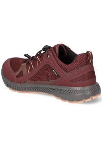 Chaussure de randonnée en mesh respirant bordeaux avec système de laçage verrouillable, label Gore-Tex, col rembourré et semelle grise texturée avec bande de roulement marron clair.