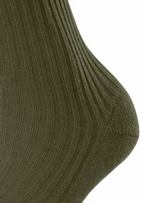 Skarpetki w oliwkowym kolorze z prążkowanym wzorem, z wzmocnioną piętą i gładkim szwem u palców. Tkanina wydaje się miękka i trwała.