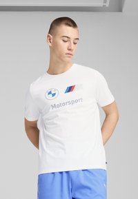 Hvid bomulds t-shirt med BMW og Motorsport logoer i blå og rød. Korte ærmer med en afslappet pasform. Enkel, ren design.