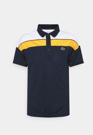 Polo med korte ærmer i marineblå med hvide og orange vandrette striber og et grønt krokodillelogo på brystet.
