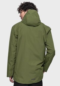 Grüne wasserfeste Jacke mit Kapuze, ausgestattet mit einer glatten Textur, langen Ärmeln und einem etwas längeren Rückensaum. Verstellbare Bündchen und minimale Markenkennzeichnung.