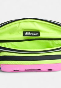 Sac zippé multicolore avec un intérieur vert néon, bordé de noir et arborant une étiquette de marque bien visible. Matériau doux et texturé.