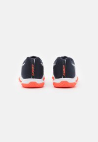 Chaussures de sport pour hommes avec une tige en maille bleu marine, une semelle intermédiaire blanche et une semelle extérieure orange vif. Détails réfléchissants le long des côtés.