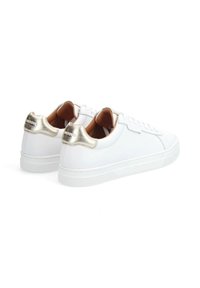 Baskets blanches avec une finition lisse, dotées d'une accentuation dorée métallique à l'arrière et de coutures subtiles, complétées par une semelle en caoutchouc texturé.