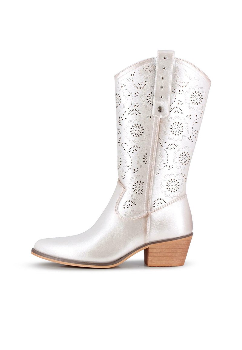 Bota de vaquero metálica plateada con patrones de corte floral, punta afilada y tacón de madera apilada. Presenta una correa con múltiples agujeros de ajuste.