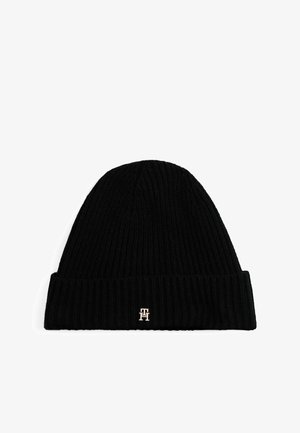 Zwarte gebreide beanie met een geribbelde textuur. Heeft een omgevouwde rand en een klein metalen logoaccent in goud aan de voorkant.