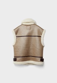 Světle béžový kožený bezrukávový vest s hnědými koženými detaily, načechraným bílým lemem podél límce a spodního okraje a hnědým sponkovým detailem.