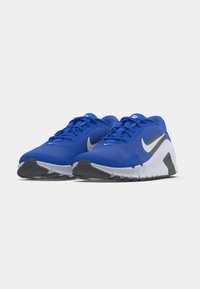 Μπλε αθλητικά παπούτσια με υφασμάτινο επάνω μέρος και υφή, γκρι λεπτομέρει�ες και λευκή ενδιάμεση σόλα. Διαθέτουν επίπεδα κορδόνια και λαστιχένια εξωτερική σόλα για πρόσφυση.