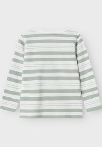 Długą bluzkę z długim rękawem, w zielono-białe poziome paski, wykonaną z miękkiej tkaniny. Prosty okrągły dekolt i luźny krój.
