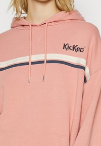 Sudadera rosa hecha de suave algodón. Presenta rayas blancas y marinas, cordones ajustables con extremos metálicos y logo bordado de Kickers.