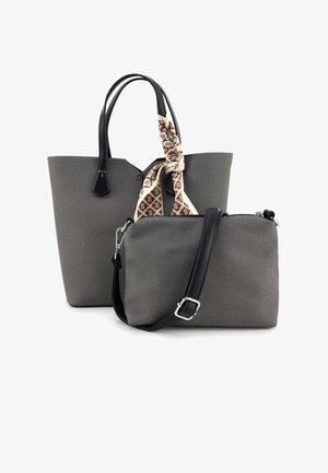 Grijze totebag met textuur en zwarte leren handvatten, met een lichte sjaal als accent. Inclusief een kleine bijpassende crossbodytas.