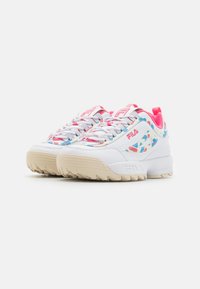 Baskets blanches avec des accents roses, un panneau latéral à motifs et des lacets texturés. Semelle épaisse avec une texture en caoutchouc beige. Grand logo Fila.