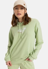 Felpa verde chiaro realizzata in tessuto morbido con tasca a marsupio e logo bianco. Presenta un cappuccio regolabile con coulisse e polsini a coste.