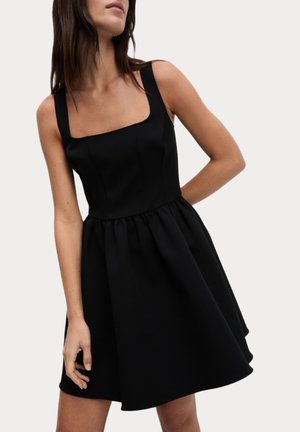 Black dress featuring a square neckline, thick straps, and a fitted bodice that transitions to a flared, gathered skirt. Smooth fabric texture.