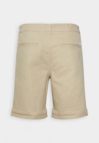 Beige kraťasy po kolena vyrobené z bavlněné směsi, s ohrnutými lemy a dvěma zadními kapsami s jemnými švy.